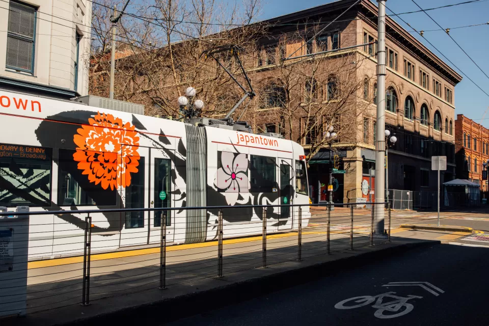 White Seattle streetcar at mid-street stop with four-story brick building in background